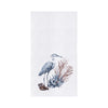 White towel with a blue heron next to blue and brown seagrass and shell.