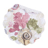 Round placemat with blush, brown, and blue seashells and vegetation.