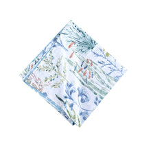  Napkin with pattern of coral, tropical fish, and shells that are light blue and green with hints of red.