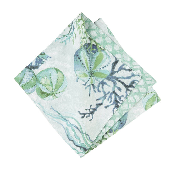 Napkin with green, teal, and blue sealife, shells, and vegetation.